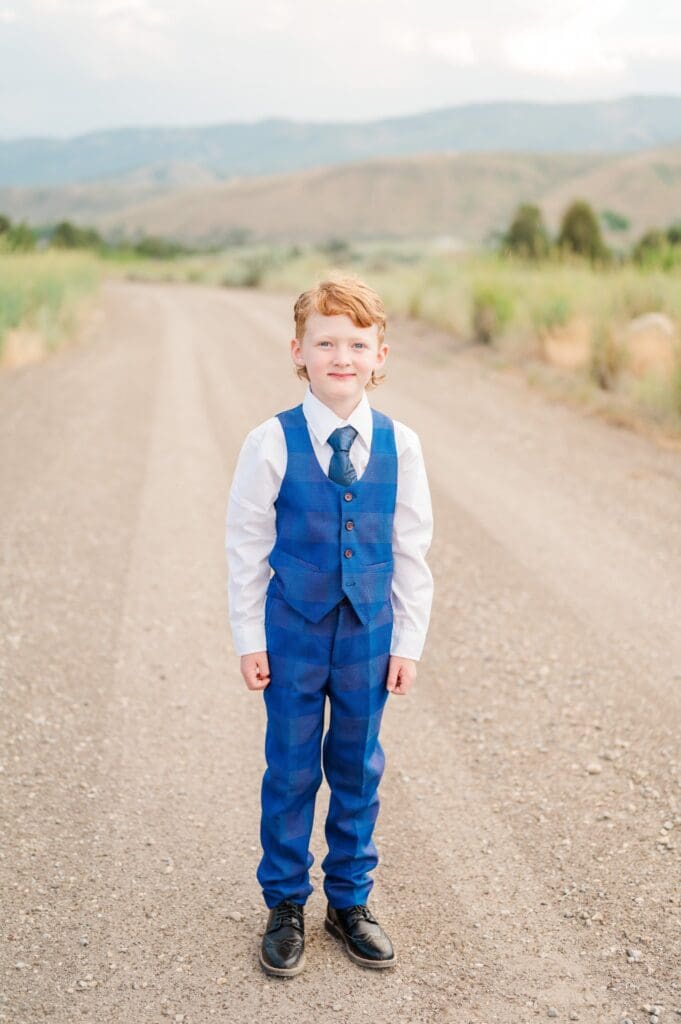 Child in navy blue suit grinning during LDS baptism session in southeast Idaho