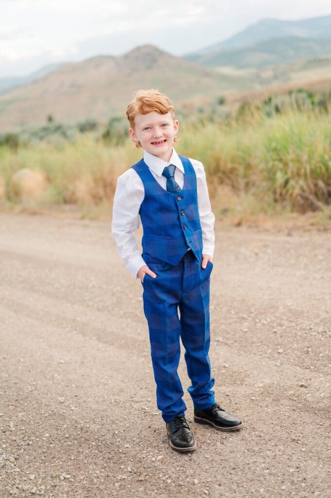 Child in navy blue suit grinning during LDS baptism session in southeast Idaho