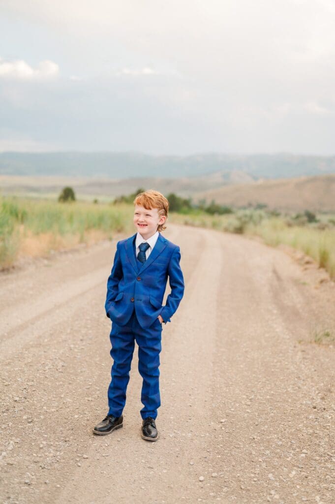 Child in navy blue suit grinning during LDS baptism session in southeast Idaho